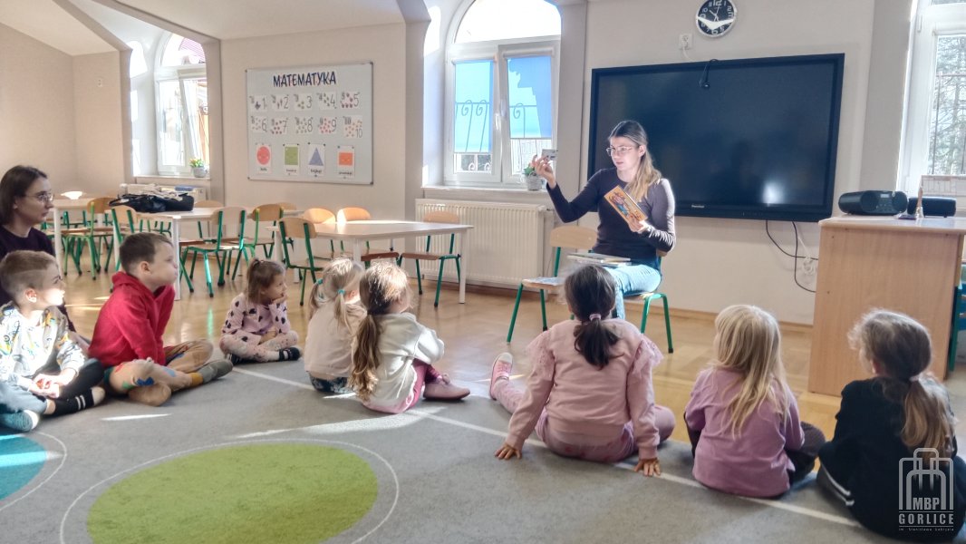 Biblioteka Gorlice, Bibliotekarka pokazuje kartę, dyplomy i ksiązki z Wyprawki Czytelniczej